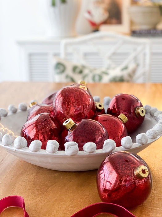 Burgundy mercury glass baubles styled together in a decorative bowl