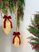 Illuminated mercury glass pinecone ornaments in two sizes styled with red velvet bows