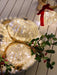 Close-up of illuminated mercury glass onion ornaments styled with Christmas greenery