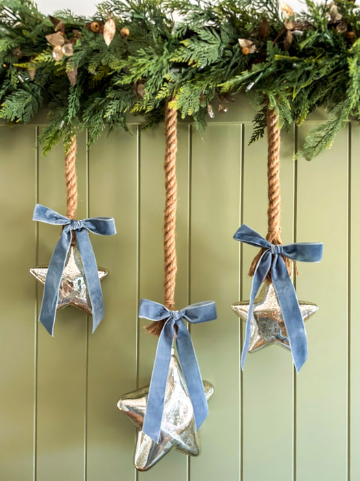 Mercury glass hanging stars styled with rope and blue velvet bows