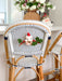 Felt hanging mouse ornament with green leaves and red berries on a woven chair
