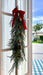 100cm Christmas swag with golden bells styled on a glass door with a red velvet bow