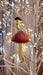 Pink velvet hanging mushroom ornament displayed on an illuminated white Christmas tree