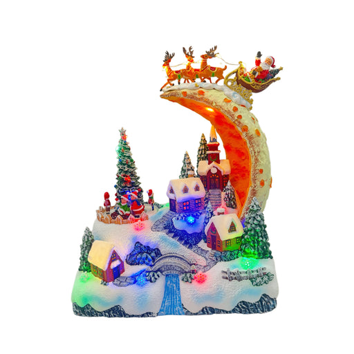 Illuminated Christmas village beneath Santa's moonlit sleigh – front view