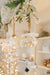 Illuminated mercury glass onion ornament hanging with a white velvet bow